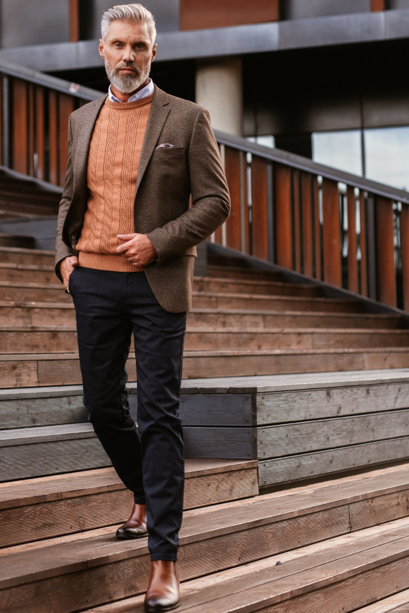 Pomarańczowy sweter męski z ażurowym splotem Villaro stylizacja z brązową marynarka