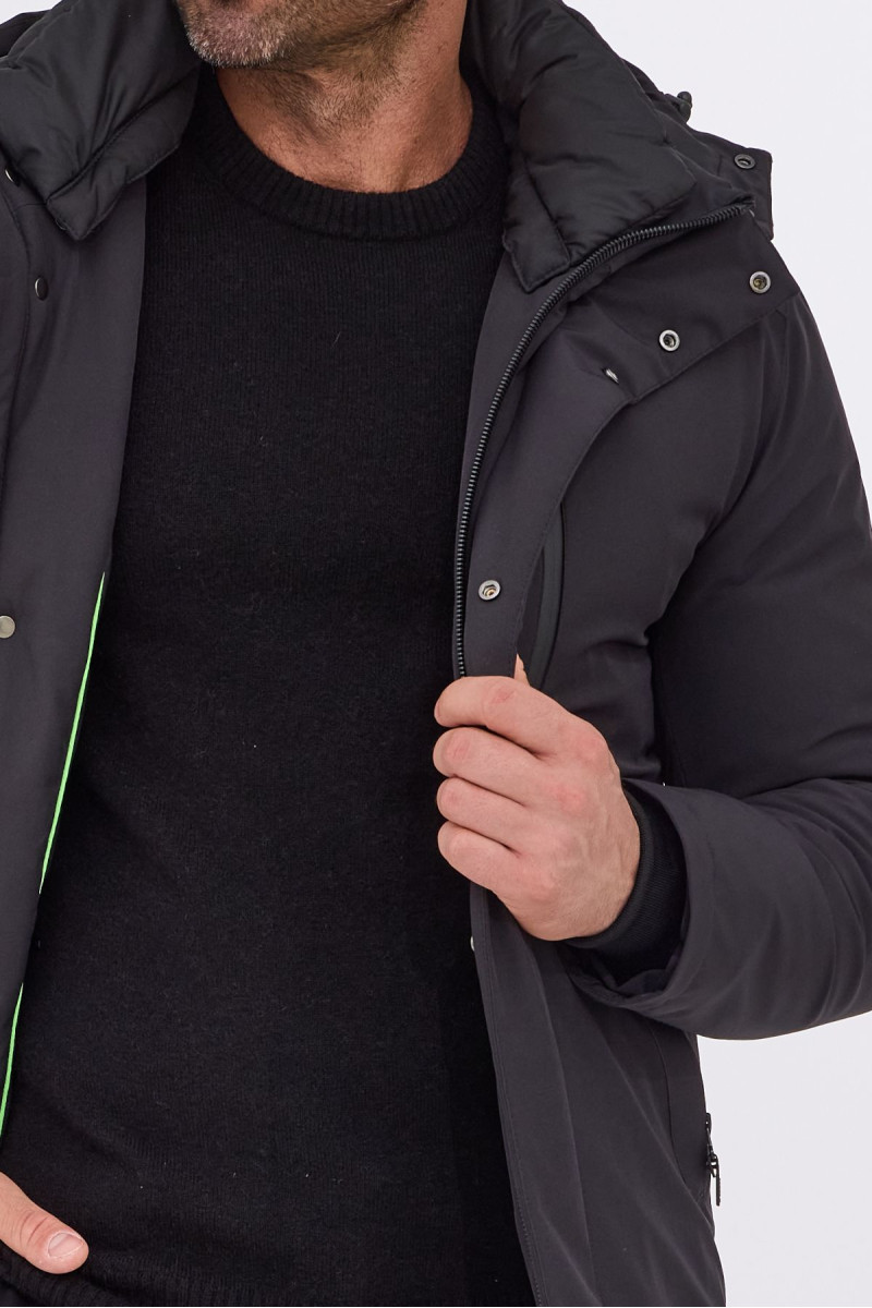 Zbliżenie na detale kurtki: zamek, metalowe napy i pikowana faktura materiału.